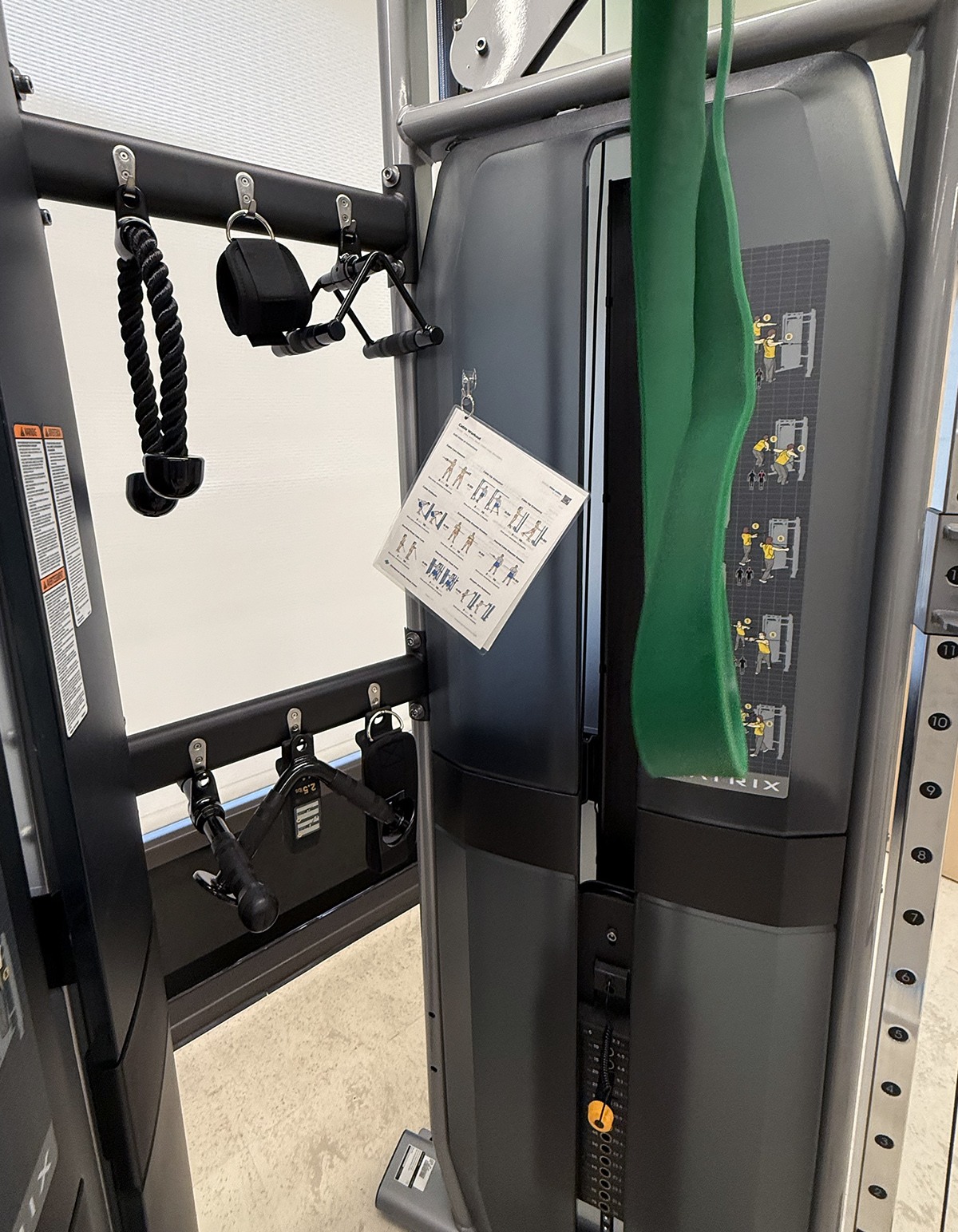 A laminated Train workout hangs directly on the cable machine at Providence Saint John’s